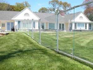 Painted stainless steel and tempered glass swimming pool fence and gates at private residence designed by Hugh J. Collins Jr. Landscape Designer, Inc.