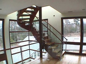 Stainless steel and glass railings system with waterjet posts and 1/2 inch thick steel -flitch- plate sandwiched between wooded stringers.