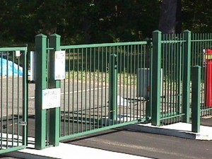 Wrought iron slide gates with monitored gate controls at storage facility.